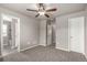 Carpeted bedroom with ceiling fan and doorways to closet and bathroom at 6707 6Th St, Frederick, CO 80530