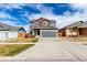 Two-story home featuring a gray exterior, red accents, and a spacious driveway leading to a two-car garage at 6707 6Th St, Frederick, CO 80530
