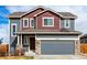 Charming two-story home with gray and red exterior, stone accents, and a two-car garage at 6707 6Th St, Frederick, CO 80530