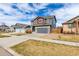 Well-kept two-story home featuring gray exterior, red accents, a two-car garage, and neighborhood street at 6707 6Th St, Frederick, CO 80530