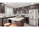 This kitchen features dark cabinets, stainless steel appliances, an island with bar seating, and stylish decor at 6707 6Th St, Frederick, CO 80530