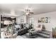 Inviting living room with gray sofa, glass-top tables, a ceiling fan, and a view into the kitchen at 6707 6Th St, Frederick, CO 80530