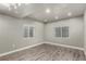 A cozy living room featuring two windows and sleek, light-colored wood flooring at 6707 6Th St, Frederick, CO 80530