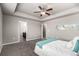 Main bedroom featuring plush carpeting, tray ceiling, ensuite bathroom and modern, decorative wall art at 6707 6Th St, Frederick, CO 80530