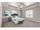 Spacious main bedroom with tray ceiling, plush carpeting, stylish decor, and ample natural light at 6707 6Th St, Frederick, CO 80530