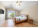 Bedroom features wood floors, a ceiling fan, and a large window providing natural light at 6833 E 115Th Ave, Thornton, CO 80233