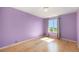 Bedroom with hardwood floors, bright purple walls, and natural lighting from a window at 6833 E 115Th Ave, Thornton, CO 80233