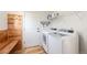 Functional laundry room with washer, dryer, storage shelf, and convenient bench at 6833 E 115Th Ave, Thornton, CO 80233
