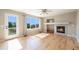 Cozy living room with hardwood floors, fireplace, and large windows with natural light at 6833 E 115Th Ave, Thornton, CO 80233