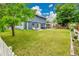 Expansive backyard with lush green lawn, mature trees, a patio set, and a charming white picket fence at 10925 W Montana Pl, Lakewood, CO 80232