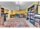 Spacious basement with a large area rug, desk, dark shelving, and neutral colored walls that create an inviting atmosphere at 10925 W Montana Pl, Lakewood, CO 80232