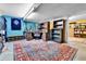 Finished basement with blue accent wall, a decorative rug, dart board, guitars, shelving, and a work desk at 10925 W Montana Pl, Lakewood, CO 80232