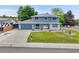 Charming two-story home with a well-manicured lawn, blue siding, a driveway, and a quaint front porch at 10925 W Montana Pl, Lakewood, CO 80232