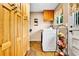 Functional laundry room featuring ample storage cabinets, a front load washer, tile floors, and a fruit basket at 10925 W Montana Pl, Lakewood, CO 80232