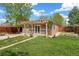 A relaxing backyard featuring a pergola, garden, and privacy fence at 2965 Ivy St, Denver, CO 80207