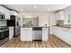 Modern kitchen boasts stainless appliances, island with seating, and sleek white cabinetry at 2965 Ivy St, Denver, CO 80207