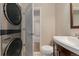 Modern laundry area features a washer and dryer stacked, and a neutral color scheme at 2965 Ivy St, Denver, CO 80207