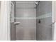 Updated shower with sleek gray tile, glass block window, and modern fixtures at 2965 Ivy St, Denver, CO 80207