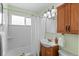 Well-lit bathroom with a shower/tub combo and wood vanity cabinet at 2248 Lima St, Aurora, CO 80010