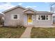 Quaint home with a sunny yellow front door, a walkway and manicured front lawn at 2248 Lima St, Aurora, CO 80010