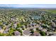 Expansive aerial view of a suburban neighborhood featuring a lake, park, and residential streets at 9745 Hummingbird Pl, Littleton, CO 80125
