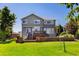 Two-story home featuring a spacious backyard with a deck and retaining wall at 9745 Hummingbird Pl, Littleton, CO 80125