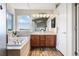 Bright bathroom with double vanity, large tub and a window overlooking a scenic view at 9745 Hummingbird Pl, Littleton, CO 80125