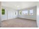 Empty bedroom featuring neutral carpet, light blue walls, and multiple windows with neighborhood views at 9745 Hummingbird Pl, Littleton, CO 80125