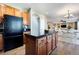 Kitchen with wood cabinets, black appliances, center island, and an adjoining dining area at 9745 Hummingbird Pl, Littleton, CO 80125