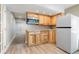 Compact kitchenette with wooden cabinets, stainless steel microwave, and vinyl flooring at 9745 Hummingbird Pl, Littleton, CO 80125