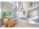 Bright living room with soaring ceilings, many windows, and neutral carpet at 9745 Hummingbird Pl, Littleton, CO 80125