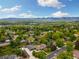 Expansive aerial view of a suburban neighborhood with mature trees and stunning mountain views in the distance at 10380 W Warren Ave, Lakewood, CO 80227