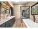 Spa-like bathroom with modern fixtures, soaking tub, glass-enclosed shower, and stylish vanity at 10380 W Warren Ave, Lakewood, CO 80227
