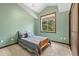 Cozy bedroom with vaulted ceilings, a comfortable bed, and a large window with a wooded view at 10380 W Warren Ave, Lakewood, CO 80227
