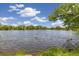 Scenic lake view with ducks swimming, lush greenery, and blue sky with fluffy clouds at 10380 W Warren Ave, Lakewood, CO 80227