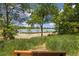 Serene lakeside view from a park bench, framed by lush greenery and a glimpse of the calm water at 10380 W Warren Ave, Lakewood, CO 80227