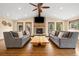 Inviting living room featuring a stone fireplace, wood floors, large windows, and cozy seating area at 10380 W Warren Ave, Lakewood, CO 80227