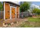 Outdoor shed featuring unique sunflower art, a wooden porch, and tidy gardening tools at 10380 W Warren Ave, Lakewood, CO 80227