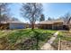 Well-maintained backyard with healthy green grass, pathway and a covered patio, ideal for gardening and outdoor activities at 620 Newport St, Denver, CO 80220