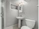Bathroom features a pedestal sink, toilet, and shower with glass door at 620 Newport St, Denver, CO 80220
