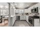 Modern kitchen with stainless steel appliances, gray backsplash, and plenty of cabinet space at 620 Newport St, Denver, CO 80220