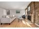 Sun-lit living room features hardwood floors, brick fireplace, and neutral decor at 620 Newport St, Denver, CO 80220