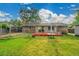 Expansive backyard featuring a red deck, lush green grass, and a vintage fireplace, perfect for outdoor enjoyment at 1030 Kohl St, Broomfield, CO 80020