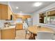 Eat-in kitchen with warm wood cabinets, tile floors, and stainless steel appliances at 1030 Kohl St, Broomfield, CO 80020