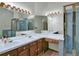 Well-lit bathroom with dual sinks, a spacious countertop, and a glass-enclosed shower, perfect for a busy lifestyle at 3426 W 98Th W Dr # A, Westminster, CO 80031