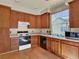 Well-lit kitchen with wooden cabinetry, black appliances, and a large window at 3426 W 98Th W Dr # A, Westminster, CO 80031