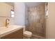 Updated bathroom with modern wood vanity, white countertop, brass fixtures, and a walk-in shower with stylish tile at 2300 S Krameria St, Denver, CO 80222