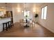 Cozy dining area with modern chandelier, hardwood floors, and stainless steel appliances in background at 2300 S Krameria St, Denver, CO 80222