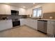 Modern kitchen with white cabinets, stainless steel appliances, tile backsplash, and ample counter space at 2300 S Krameria St, Denver, CO 80222