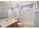 Bathroom with cherry blossom shower curtain, single sink vanity, and tub-shower combo at 11416 E 114Th Ave, Commerce City, CO 80640